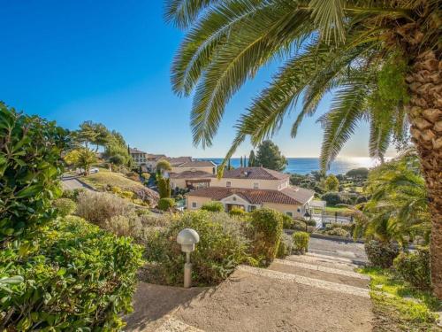 a palm tree and stairs leading to a house at Dans un cadre d'exception, Vue mer panoramique à Agay Côte d'Azur, Village Vacances Cap Esterel, 2 chambres, avec jardin, golf, climatisation, Wifi, 5 piscines in Agay - Saint Raphael