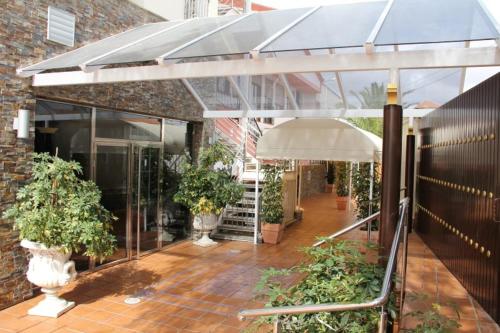 a patio with plants and an umbrella in a building at Hotel Frijon in Aceuchal