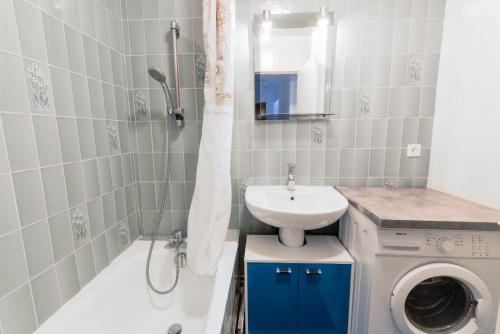une salle de bain avec un lavabo et une machine à laver dans l'établissement Cosy family flat, à Clichy