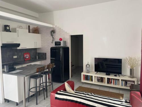 Il comprend une cuisine équipée d'un réfrigérateur noir et d'un comptoir. dans l'établissement Chez Georges, à Sète