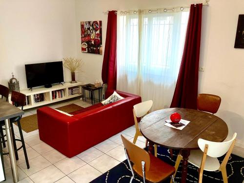 un salon avec un canapé rouge et une table dans l'établissement Chez Georges, à Sète