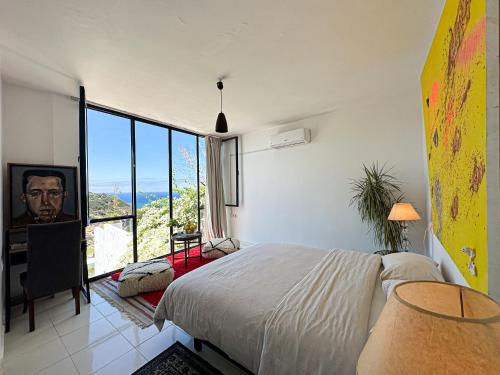 a bedroom with a bed and a large window at Mar y Montana House in Tangier