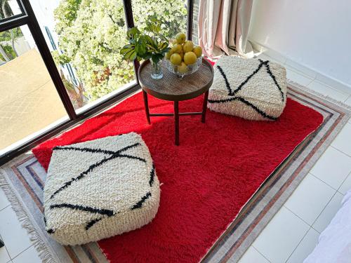 a room with a red rug and a table with fruit on it at Mar y Montana House in Tangier