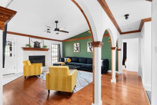a living room with a black couch and yellow chairs at Serene Family Retreat King Beds Pool Hot Tub and Games in Cedar Park