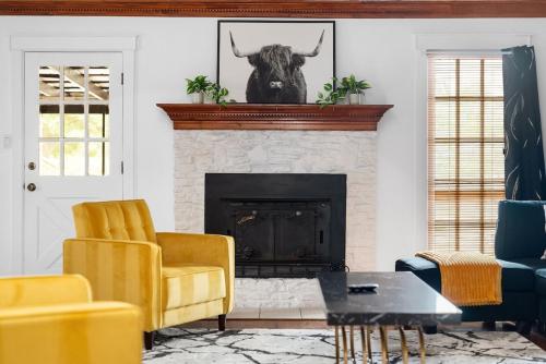 a living room with yellow chairs and a fireplace at Serene Family Retreat King Beds Pool Hot Tub and Games in Cedar Park