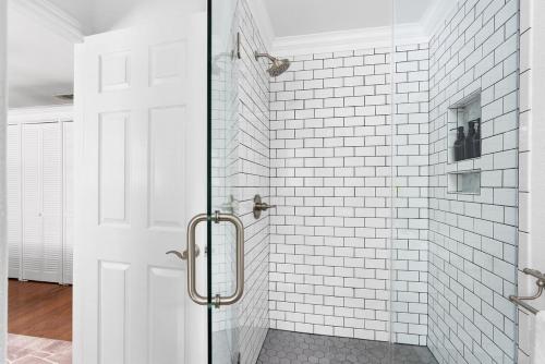 a white bathroom with a glass shower door at Serene Family Retreat King Beds Pool Hot Tub and Games in Cedar Park
