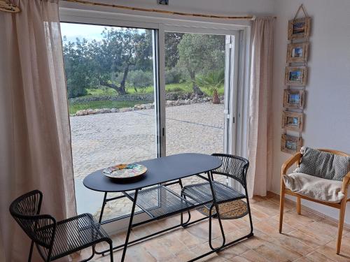 una mesa y sillas frente a una puerta corredera de cristal en Deluxe Room Santa Barbara de Nexe, en Santa Bárbara de Nexe