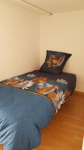 une chambre avec un lit avec une couette colorée dans l'établissement Studio meublé en sous-sol en plein centre ville, à La Ferté-Bernard