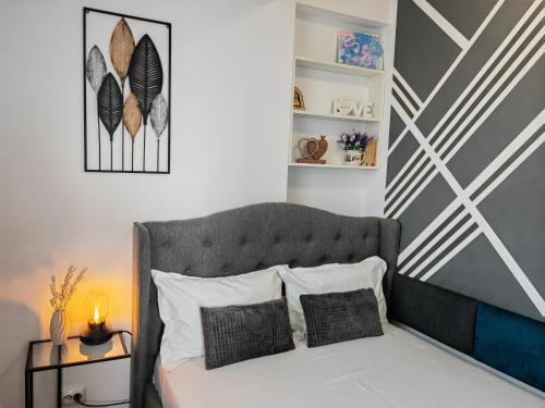 1 dormitorio con 1 cama con cabecero gris en Sunset Bucharest 84, en Bucarest