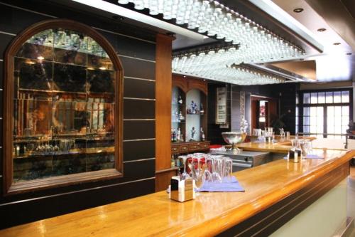 a bar in a restaurant with glasses on the counter at Hotel Frijon in Aceuchal