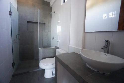 ein Badezimmer mit Waschbecken, Toilette und Dusche in der Unterkunft Edificio Regam in El Cuyo