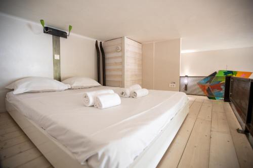 une chambre avec un grand lit blanc avec des serviettes dessus dans l'établissement La loge Theuriet - Bord de lac, à Annecy