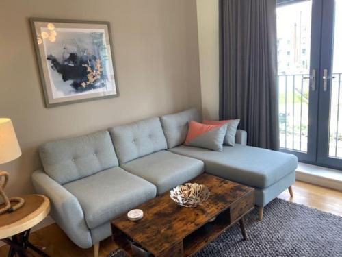a living room with a blue couch and a coffee table at Modern house by the canal in Southall