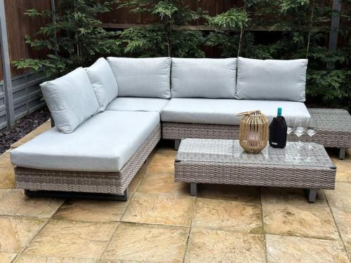 a white couch and a table on a patio at Modern house by the canal in Southall
