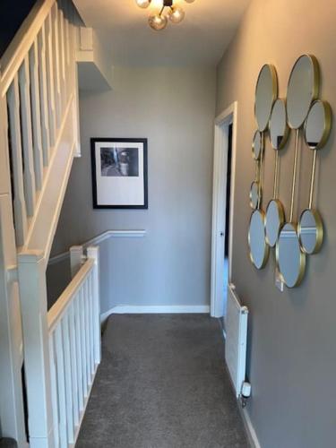 a hallway with a staircase with mirrors on the wall at Modern house by the canal in Southall