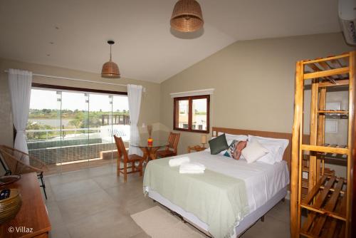 a bedroom with a bed and a table and a window at Villaz Lençóis Maranhenses in Santo Amaro