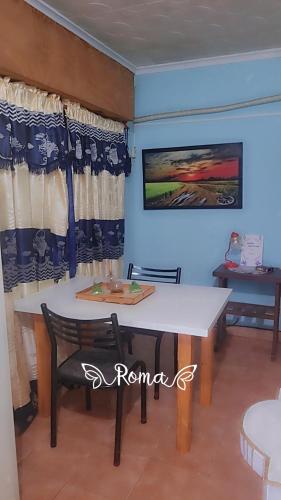 a dining room with a white table and chairs at RoMalandya in Villa Dolores