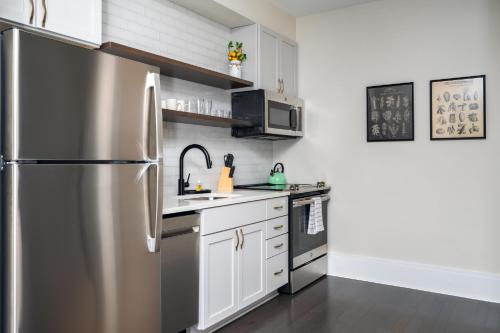 a stainless steel refrigerator in a kitchen with white cabinets at Hancock House in Louisville