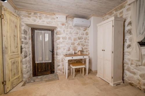 a room with a table and a stone wall at Old House Leković in Godinje