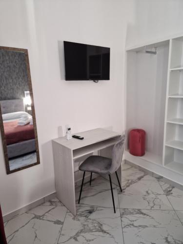 a desk with a chair and a television in a room at Eden in Lamezia Terme