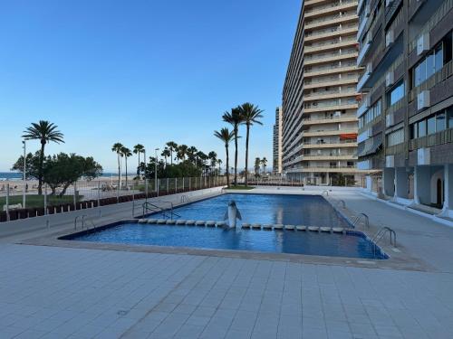a large swimming pool next to a tall building at Apto. Cullera vistas espectaculares primera línea in Cullera