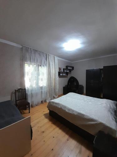 a bedroom with a large bed and a window at taisya guest house in Borjomi