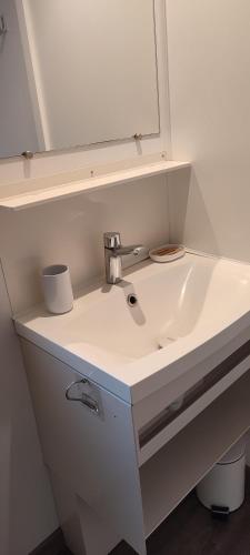 La salle de bains est pourvue d'un lavabo blanc et d'un miroir. dans l'établissement La Carabasse, à Vias