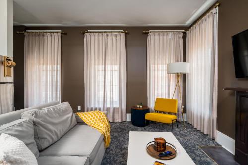 a living room with a couch and a yellow chair at Hancock House in Louisville
