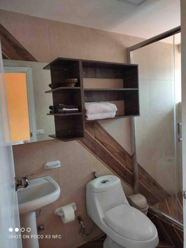 a bathroom with a toilet and a sink at ACOGEDOR DEPARTAMENTO EN CENTRO HISTÓRICO-Cuenca in Cuenca
