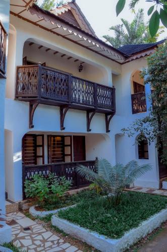 a house with a balcony on the side of it at Langi Langi Beach Bungalows in Nungwi