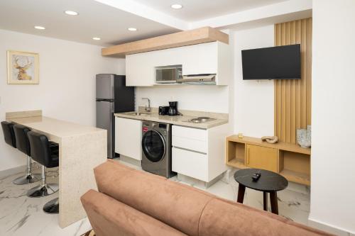 a living room with a couch and a kitchen at Lujo y modernidad en conexión in Cancún