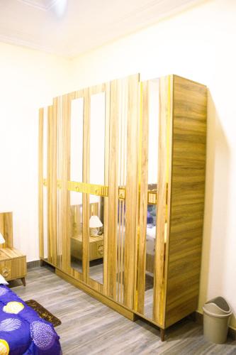 a room with a large wooden closet with a mirror at Adji's Cozy Villa in Apenkwa