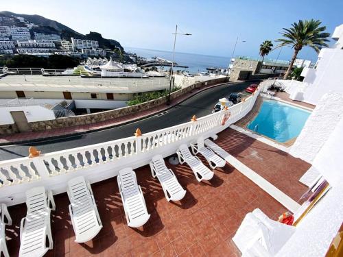balcón con sillas blancas y piscina en Bonaire Pura Vida, en Puerto Rico de Gran Canaria