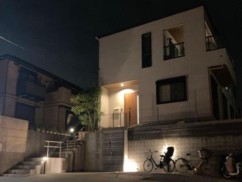 two bikes parked in front of a building at night at 104号室 海の見えるシェアハウスRoopt Hayama Collective Houseの一室 in Hayama