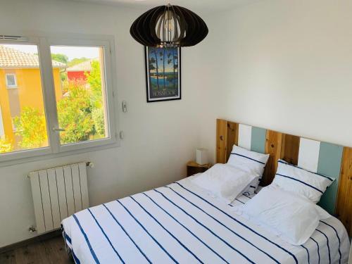 - une chambre avec un lit bleu et blanc et une fenêtre dans l'établissement Charming Quiet House in Soorts Hossegor - Pedebert Area -- Certified 3 stars Holiday Home, à Soorts-Hossegor