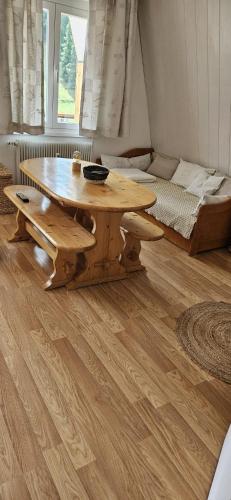 - une table et un banc en bois dans une chambre avec un lit dans l'établissement Deux pièces face aux pistes, à Péone