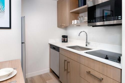 a kitchen with a sink and a microwave at Homewood Suites by Hilton Orlando-Nearest to Universal Studios in Orlando
