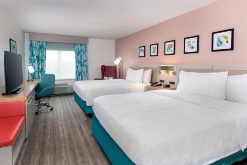 a hotel room with two beds and a flat screen tv at Hilton Garden Inn Orlando International Drive North in Orlando