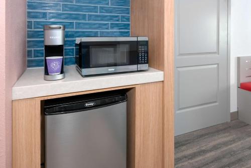 a microwave sitting on a counter next to a dishwasher at Hilton Garden Inn Orlando International Drive North in Orlando
