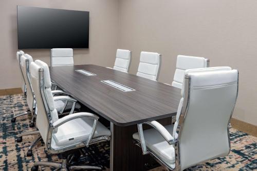 a conference room with a wooden table and white chairs at Hilton Garden Inn Orlando International Drive North in Orlando