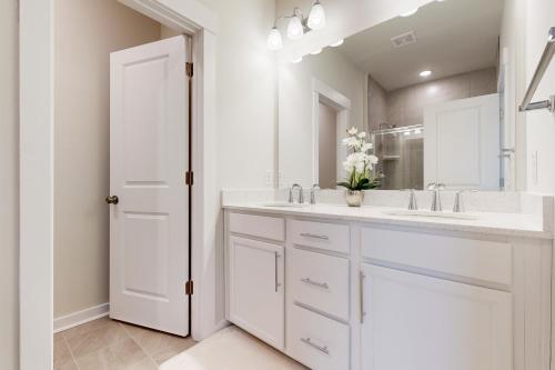 a white bathroom with a sink and a mirror at Hanahan Haven in Charleston