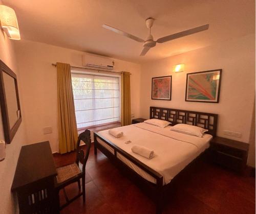 a bedroom with a large bed and a window at Jungle Hut-Annabelle's Beach Apartments at Bernard Simao,Calangute,Goa in Candolim