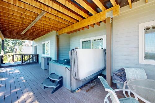 a covered deck with a pool table and chairs at Capeside Paradise in Pacific City