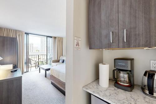a hotel room with a kitchen and a bedroom at Palms at Waikiki #311 in Honolulu