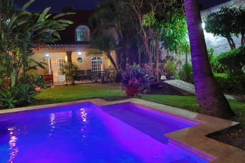 a pool with purple lights in front of a house at La casa de la tía 3B Cuernavaca in Acapantzingo