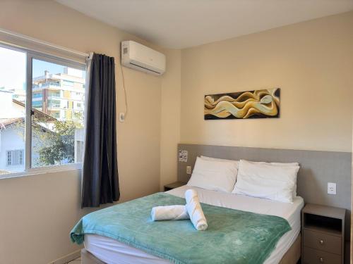 a bedroom with a bed and a window at Residencial 364 – Prime Location, Just 5 Minutes from the Beach in Bombinhas