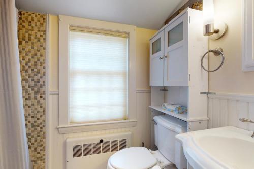 a bathroom with a toilet and a window at Cozy & Quiet Hyannis Retreat in Hyannis