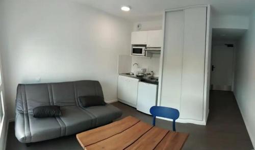 un salon avec un canapé et une table et une cuisine dans l'établissement A4-16 Studio Cosy Toulouse, à Toulouse