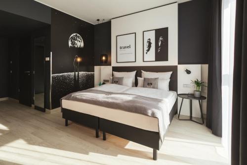 a bedroom with a large bed with black walls at Holiday Inn - the niu Star Sindelfingen by IHG in Sindelfingen