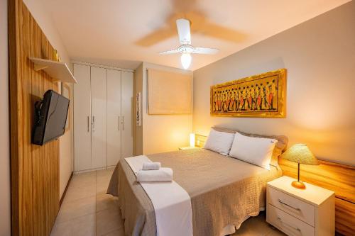 a bedroom with a bed and a flat screen tv at Moderno 1 Quarto Dentro da Vila in Praia do Forte